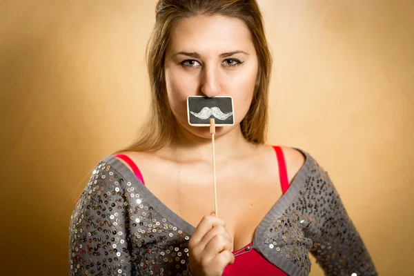 Retrato de mulher bonito segurando bigode decorativo — Fotografia de Stock