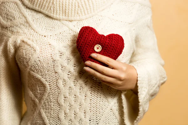 Foto di donna in posa con il cuore rosso a maglia sul petto — Foto Stock