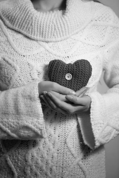 Monochrome photo of woman n sweater posing with decorative heart — Stock Photo, Image