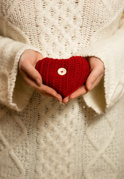 Mulher em suéter segurando coração de malha vermelho — Fotografia de Stock