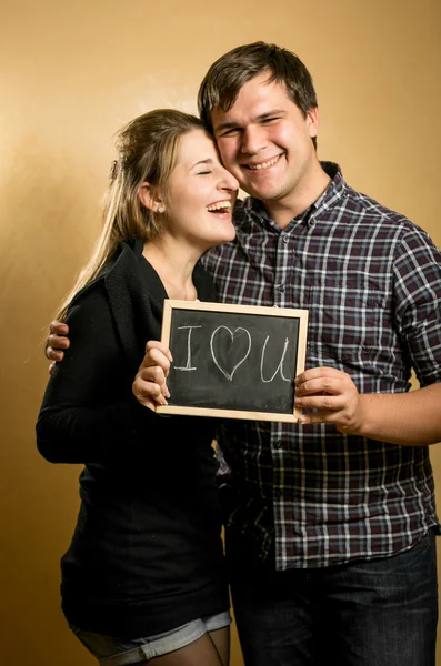 Couple en amour tenant tableau noir avec mot écrit "Amour " — Photo