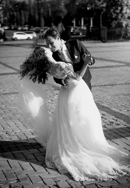 Monocromo tiro de besar novia y novio en la calle en el viento da —  Fotos de Stock