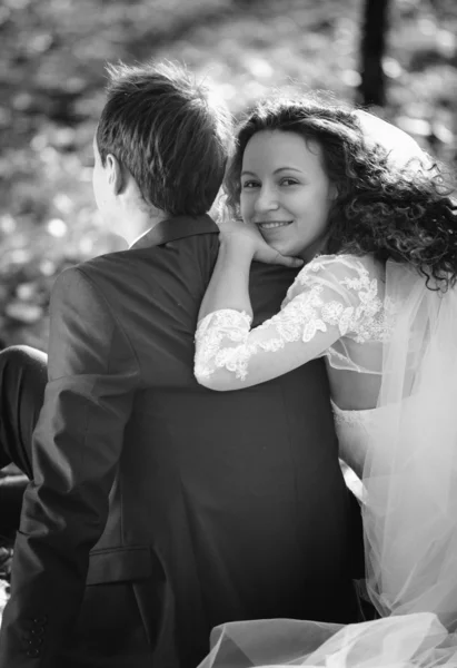 Monochrome portrait of cute smiling bride hugging grooms back wh — Stock Photo, Image