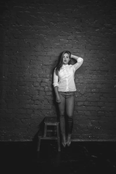 Monochrome glamour photo of woman posing against brick wall — Stock Photo, Image