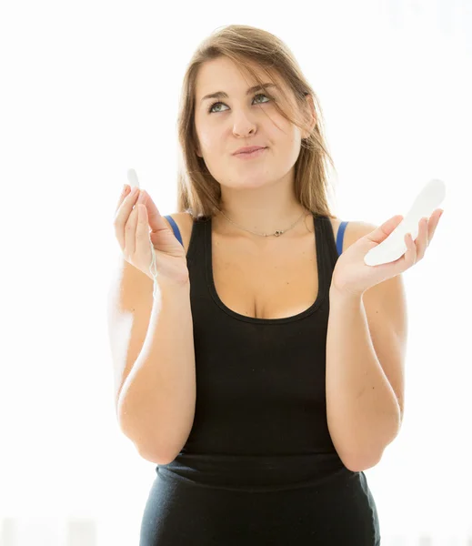 Cute brunette woman choosing between menstrual pad and tampon — Stock Photo, Image