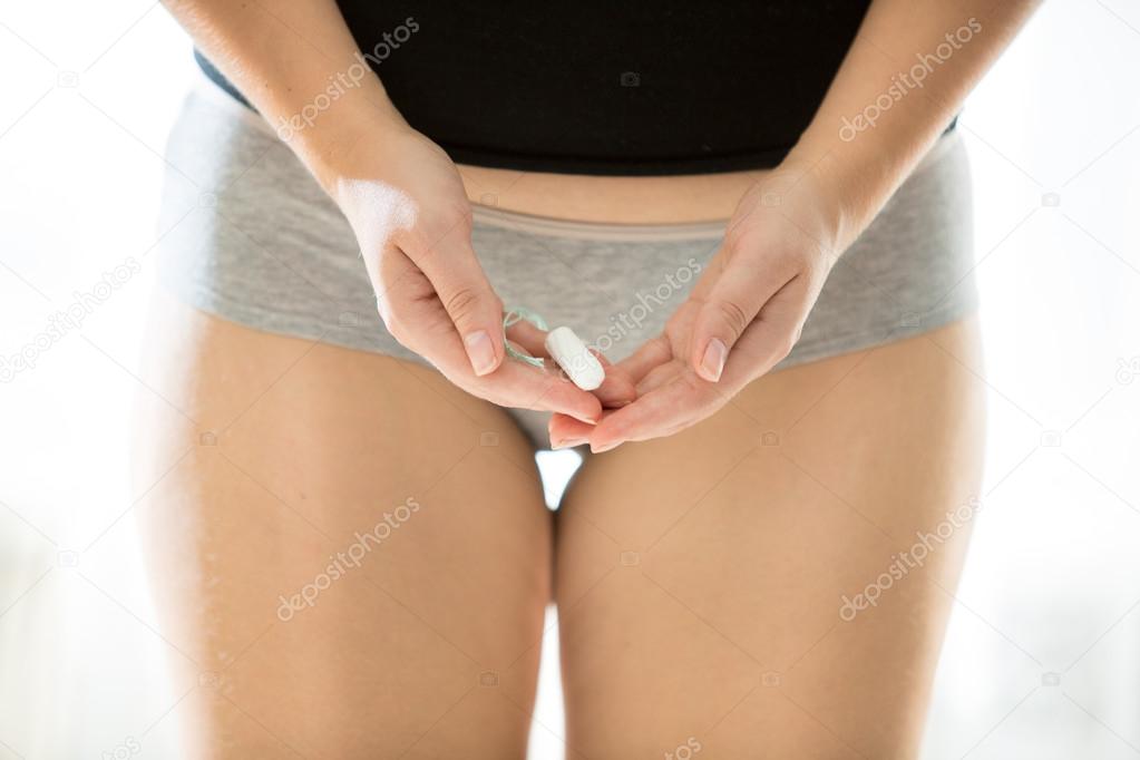 photo of sexy slim woman posing with sanitary tampon