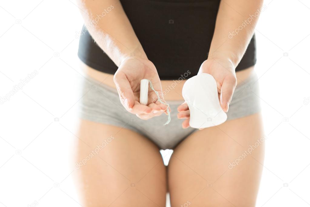young woman holding hygiene pad and tampon