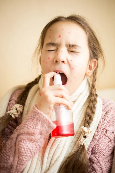 Jeune fille avec la grippe à l'aide de spray gorge — Photo