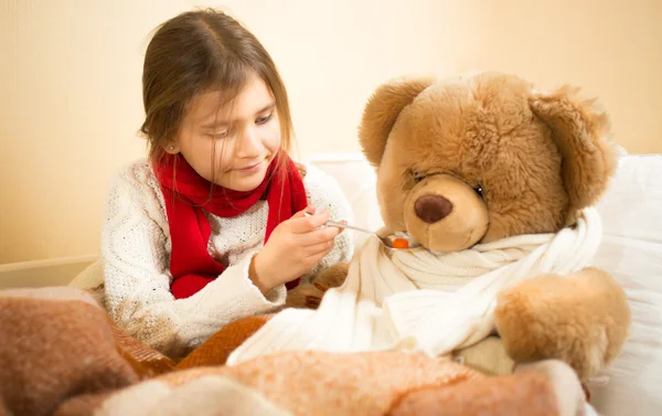 Oyuncak ayı ile hastaneye oynayan sevimli kız — Stok fotoğraf