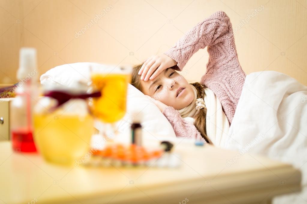 little sick girl with high temperature lying in bedroom 