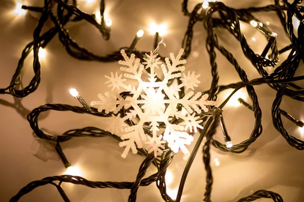 Dekorativa snöflingan liggande på julbelysning — Stockfoto