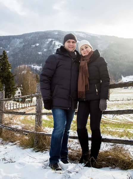 Glimlachend poseren tegen Oostenrijkse Alpen verliefde paar bedekt met s — Stockfoto