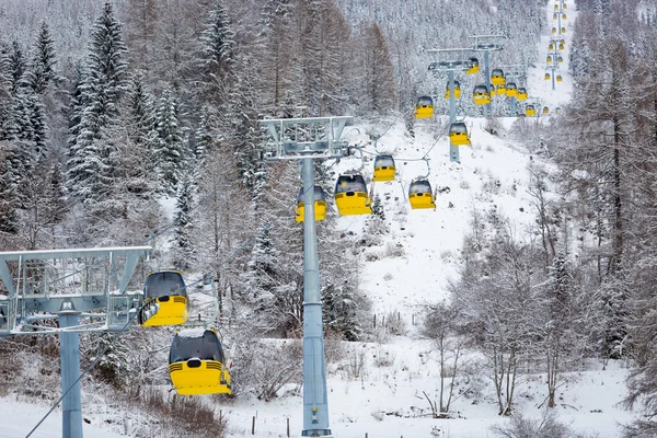 黄色的滑雪缆车车厢在阿尔卑斯山中的行 — 图库照片