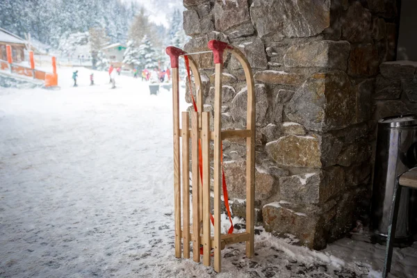 Slitte in legno vintage sulla strada accanto al muro di pietra — Foto Stock