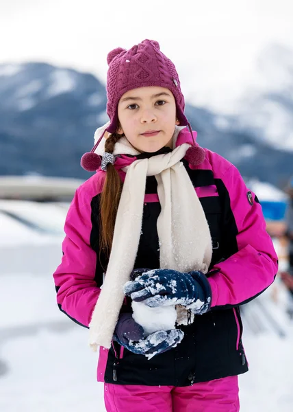Roztomilá dívka hraje v sněhové koule na vrcholu vysoké hory — Stock fotografie