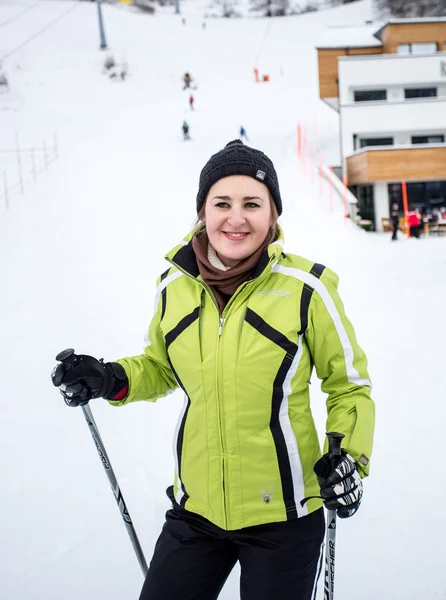 Retrato de esquiador feminino sorridente bonito na descida da pista de esqui — Fotografia de Stock