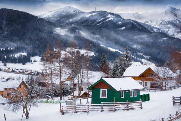 Landscape of traditional wooden houses on high mountains covered — Stock Photo, Image