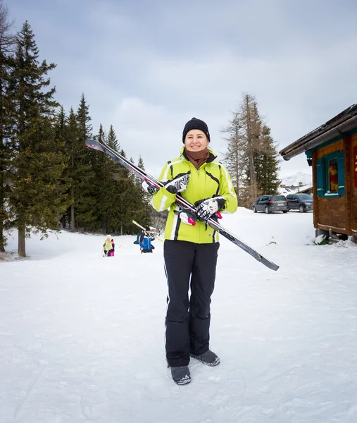 Femme souriante posant avec des skis sur la pente — Photo