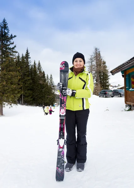 Улыбающаяся женщина позирует на вершине склона с лыжами — стоковое фото