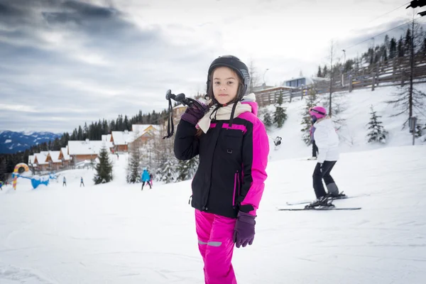 Menina posando no topo da pista de esqui com equipamento de esqui — Fotografia de Stock