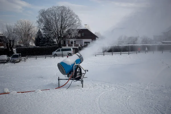 Macchina per innevare che lavora sulla pista da sci durante la giornata nuvolosa — Foto Stock