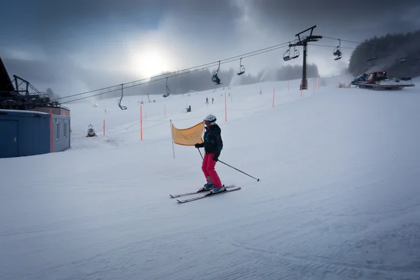 Женщина едет вниз по лыжному склону в австрийском горнолыжном курорте — стоковое фото