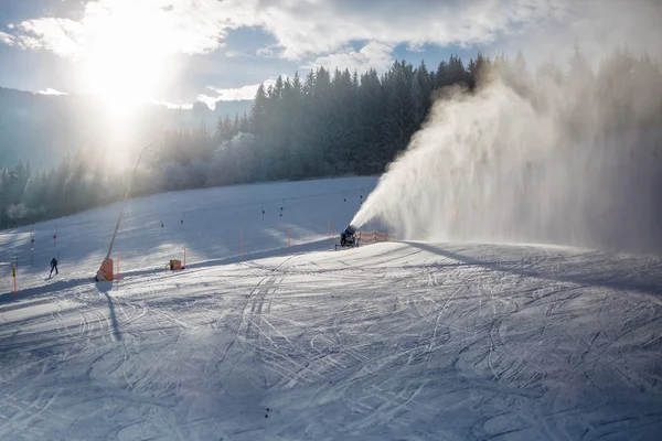 Schneekanonen am Skihang in den Alpen bei sonnigem Wetter im Einsatz — Stockfoto