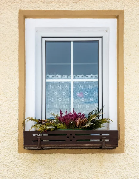 Flowers growing under window in traditional Austrian house — Stock Photo, Image