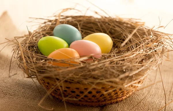 Macro shot di uova di Pasqua colorate sdraiato nel nido sul tavolo — Foto Stock