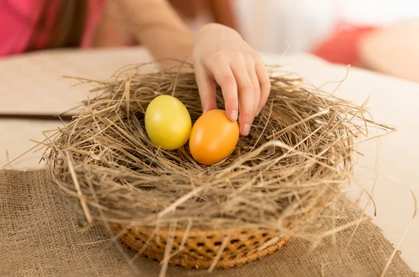 Strzał zbliżenie dłoni dziecka zbieranie jajek wielkanocnych z gniazda — Zdjęcie stockowe