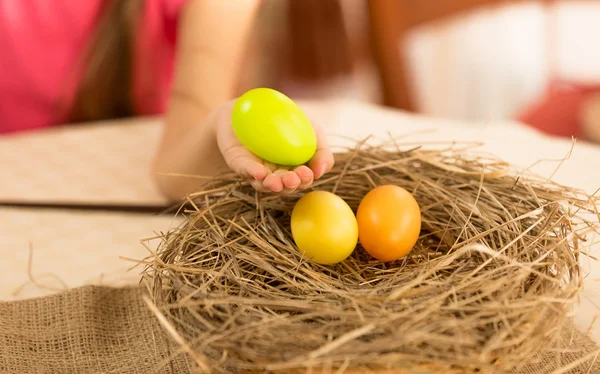 Girl taking Easter egg from the nest — Stock Photo, Image