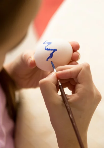 Foto di primo piano di ragazza pittura uovo di Pasqua con vernice blu — Foto Stock