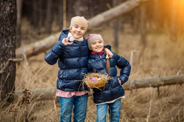 Lachende meisjes poseren met mand vol paaseieren in vorst — Stockfoto