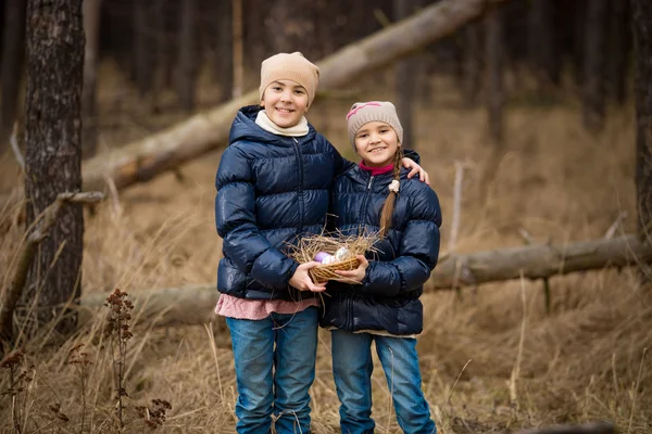 Due ragazze felici che tengono il cesto pieno di uova di Pasqua — Foto Stock