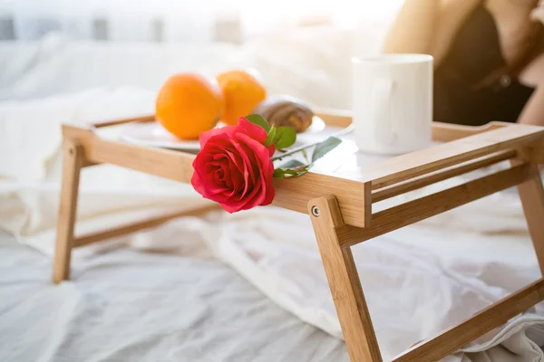 Closeup fotografie podnos se snídaní a červené růže v hotelovém pokoji — Stock fotografie