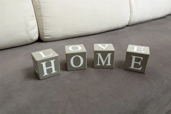Консервативный снимок слова "дом" и любви, написанной на игрушечных бричках — стоковое фото