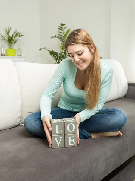 Frau hält hölzerne Ziegelsteine mit Buchstaben, die das Wort Liebe bilden — Stockfoto