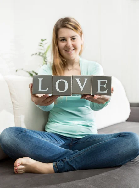 Photo of woman with word "love" made of decorative bricks — Stock Photo, Image