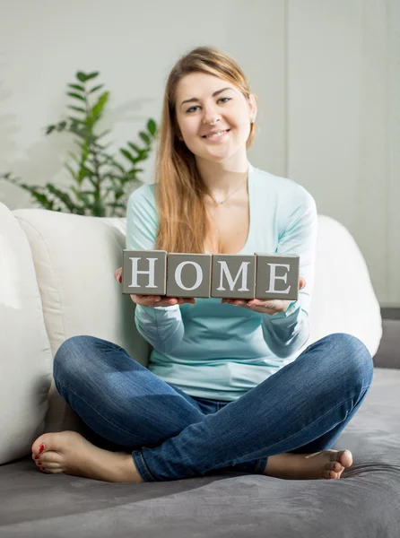 Conceptual photo of girl holding word "love" made of bricks — Stock Photo, Image