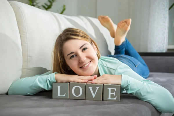 Cute woman posing with decorative word "Love" — Stock Photo, Image