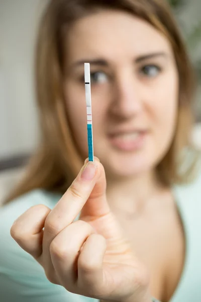 Portret van bezorgd vrouw kijken naar positieve zwangerschapstest — Stockfoto