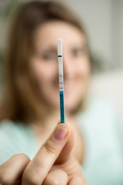 Portrait of happy woman showing positive pregnancy test — Stock Photo, Image