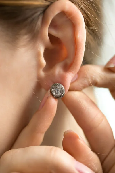 Macro shot of young woman trying on diamond earring — Stock Photo, Image