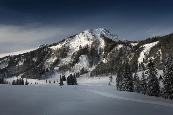 Sun lighting peaks of high mountains covered by snow — Stock Photo, Image