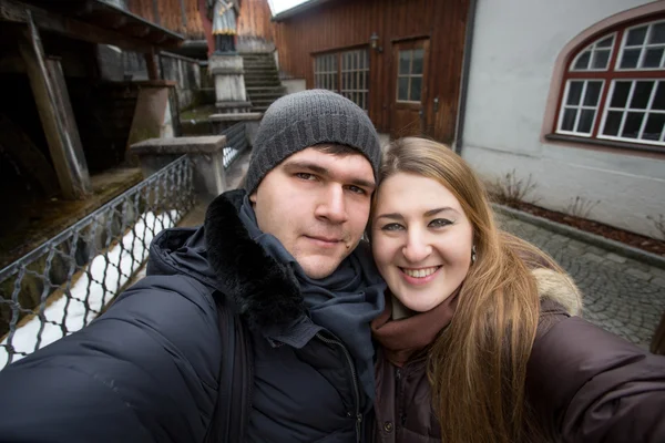 Casal sorrindo fazendo selfie na rua no dia de inverno — Fotografia de Stock