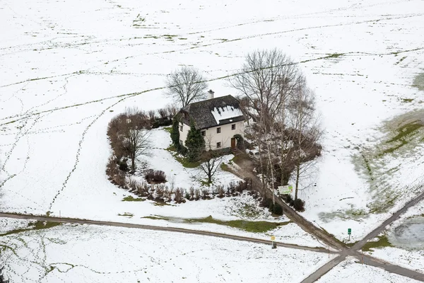 Luchtfoto op eenzame huis op vallende sneeuw in Salzburg gebied — Stockfoto