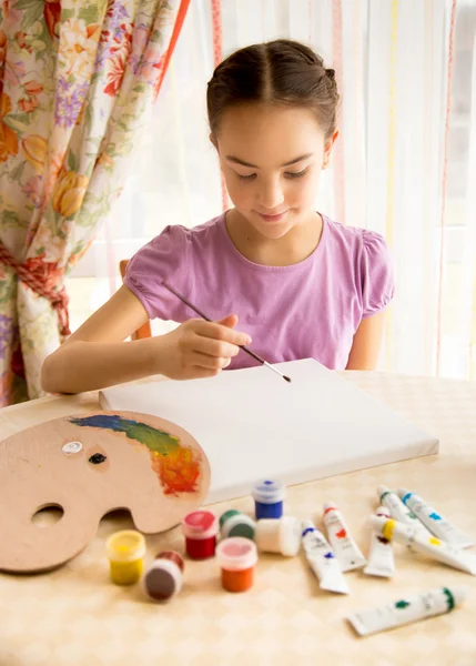 Улыбающаяся девушка рисует масляными красками на холсте — стоковое фото