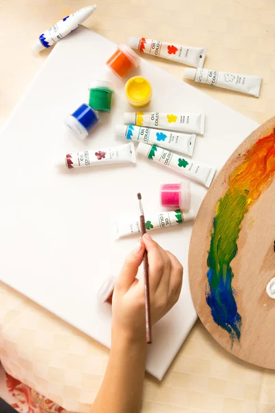 Meisje houden penseel en tekening van olieverf — Stockfoto