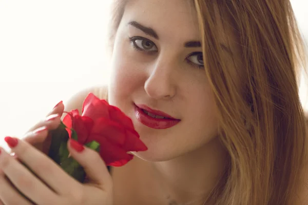 Tonificado primer plano retrato de la mujer sexy sosteniendo rosa roja — Foto de Stock