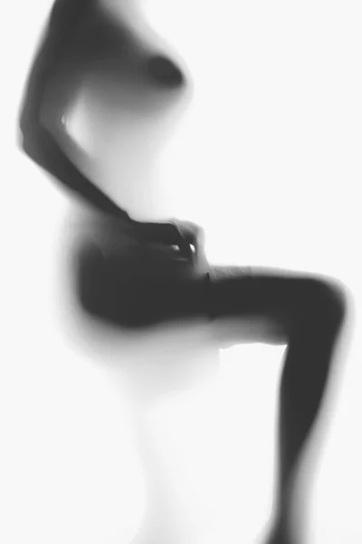 Blurred photo of sexy naked woman putting on nylon stockings — Stock Photo, Image